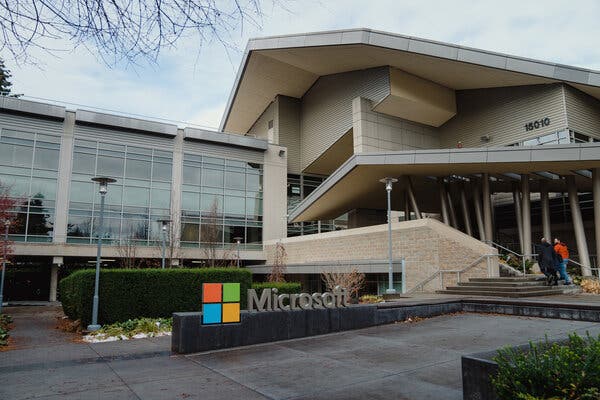 A Microsoft sign stands in front of a large, angular building.