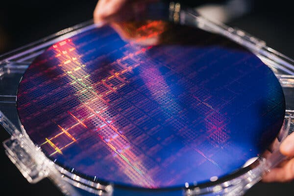 A large, blue translucent silicon disk, called a wafer and containing Sapphire Rapids chip. 