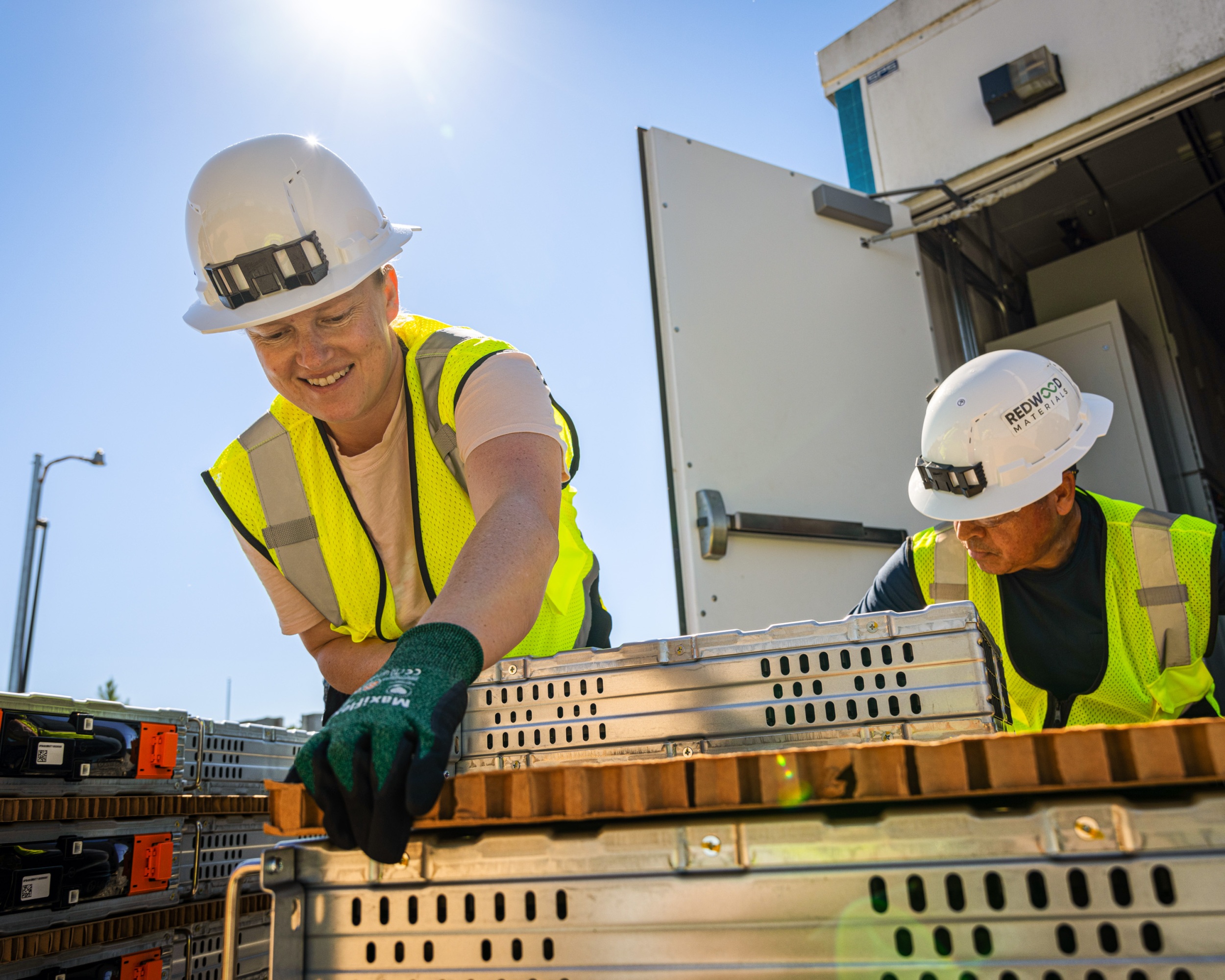 Two workers disassembling an energy storage unit