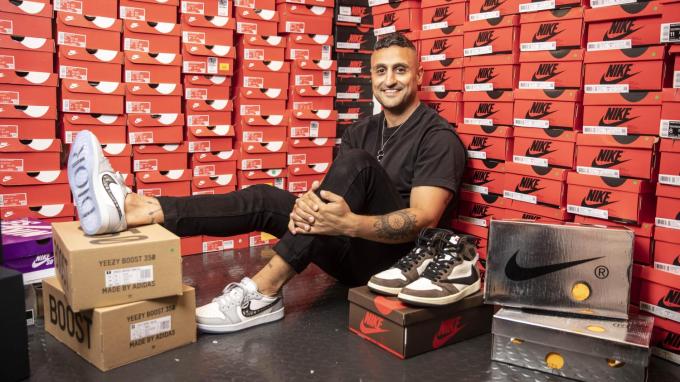 The Edit LDN founder Moses Rashid, sitting against a wall of shoeboxes with sneakers