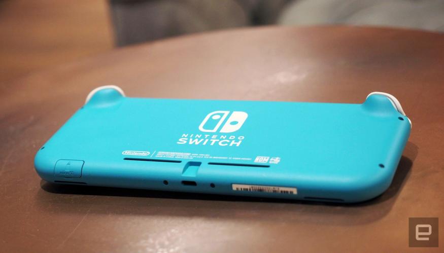 A light blue Nintendo Switch sits upside down on a coffee table.