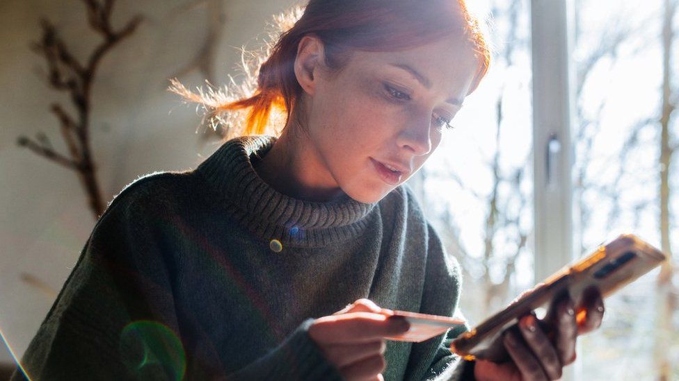 Woman making a payment with her card on her smartphone