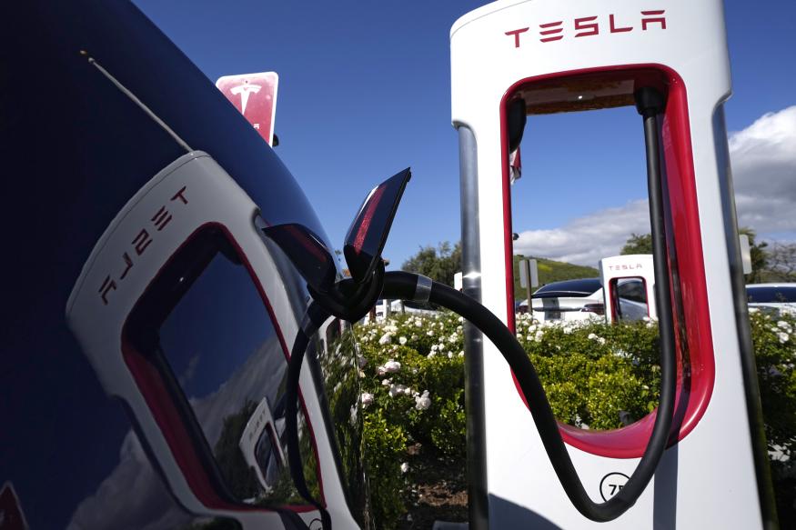 FILE - A Tesla auto charges on May 10, 2023, in Westlake, Calif. All of Ford Motor Co.'s current and future electric vehicles will have access to about 12,000 Tesla Supercharger stations starting in 2024, according to an announcement Thursday, May 25, 2023, by Ford CEO Jim Farley and Tesla CEO Elon Musk. (AP Photo/Mark J. Terrill, File)