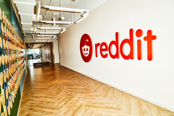 A wood-floored hallway, with the word "Reddit" in red on a white wall.