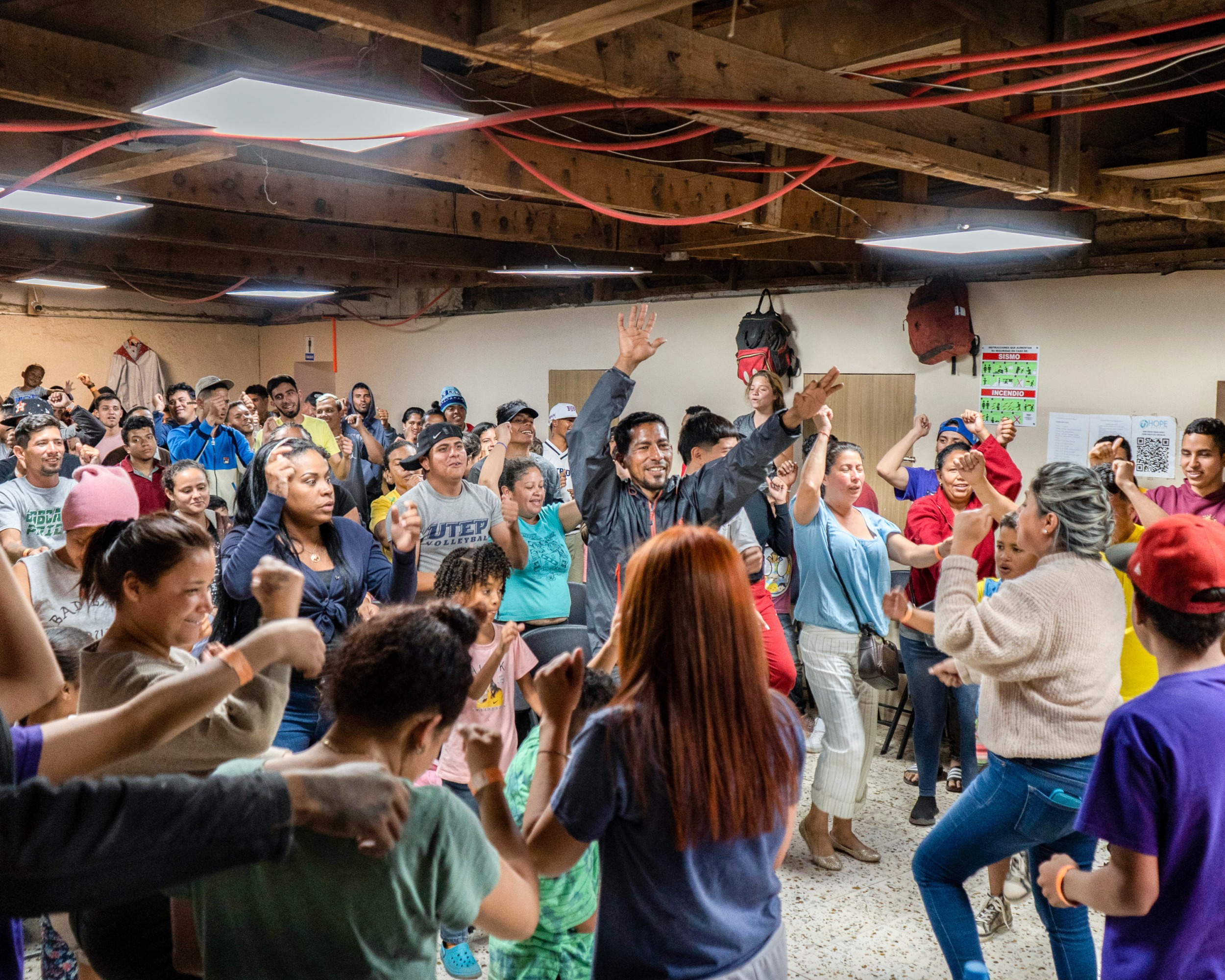 a crowd of people with their hands in the air