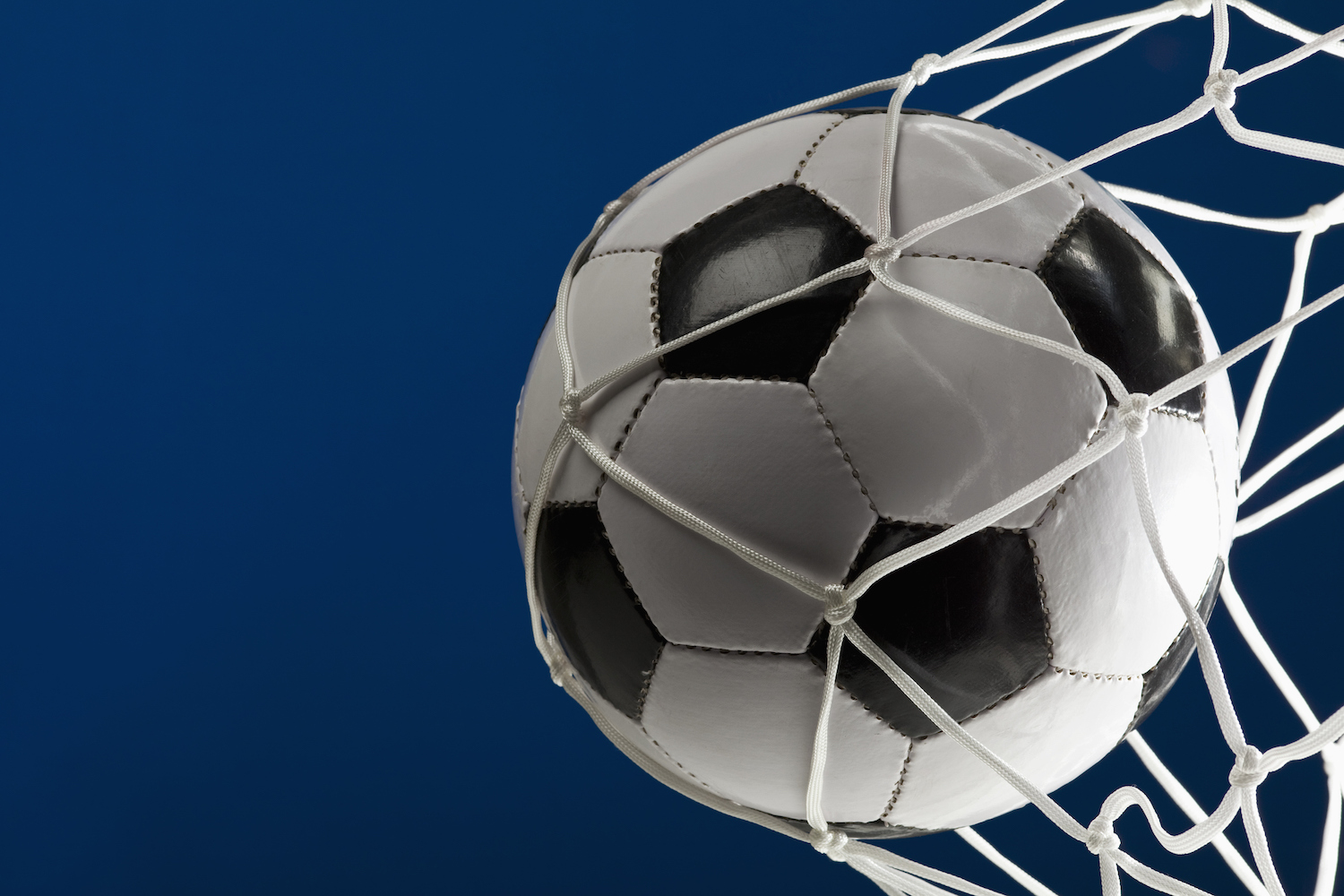 A soccer ball in a net, close-up