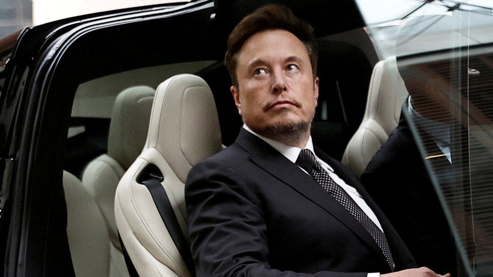 Tesla chief executive Elon Musk gets in a Tesla car as he leaves a hotel in Beijing, China.