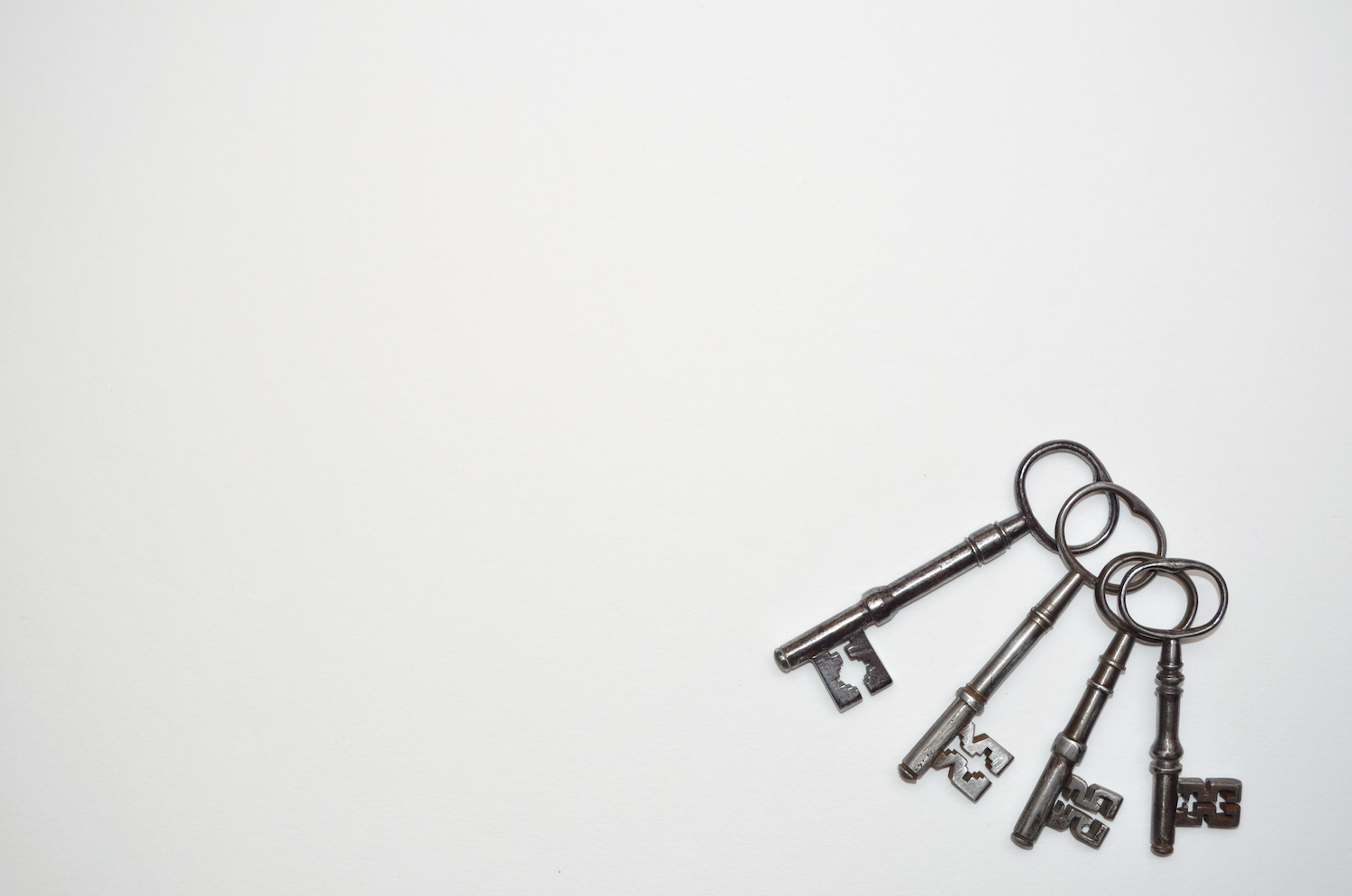 4 antique keys on a white background