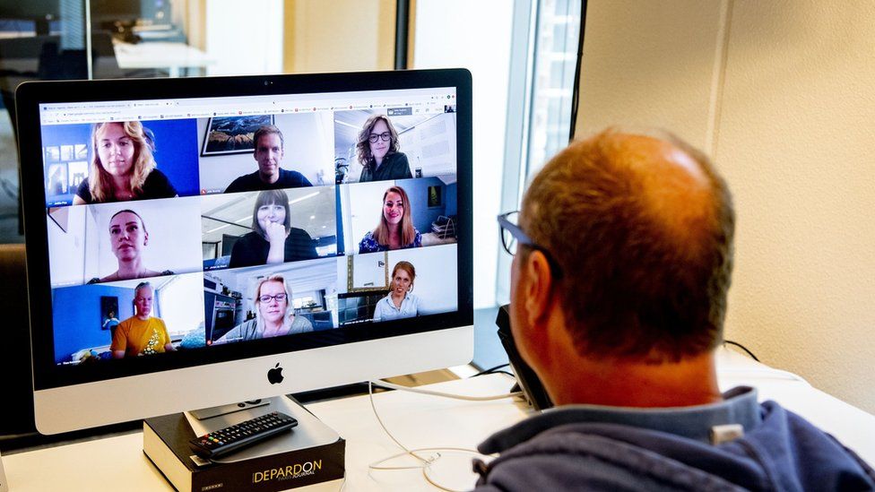 A man looks at a Zoom call on his computer