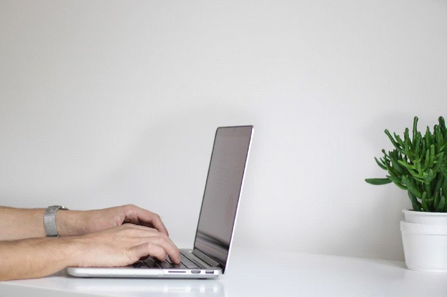 A data analyst working on a computer at their home desk while utilizing the Pareto principle.