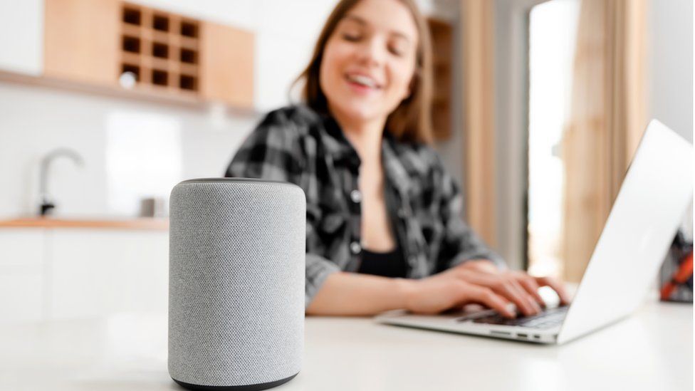 A woman looking at her voice assistant
