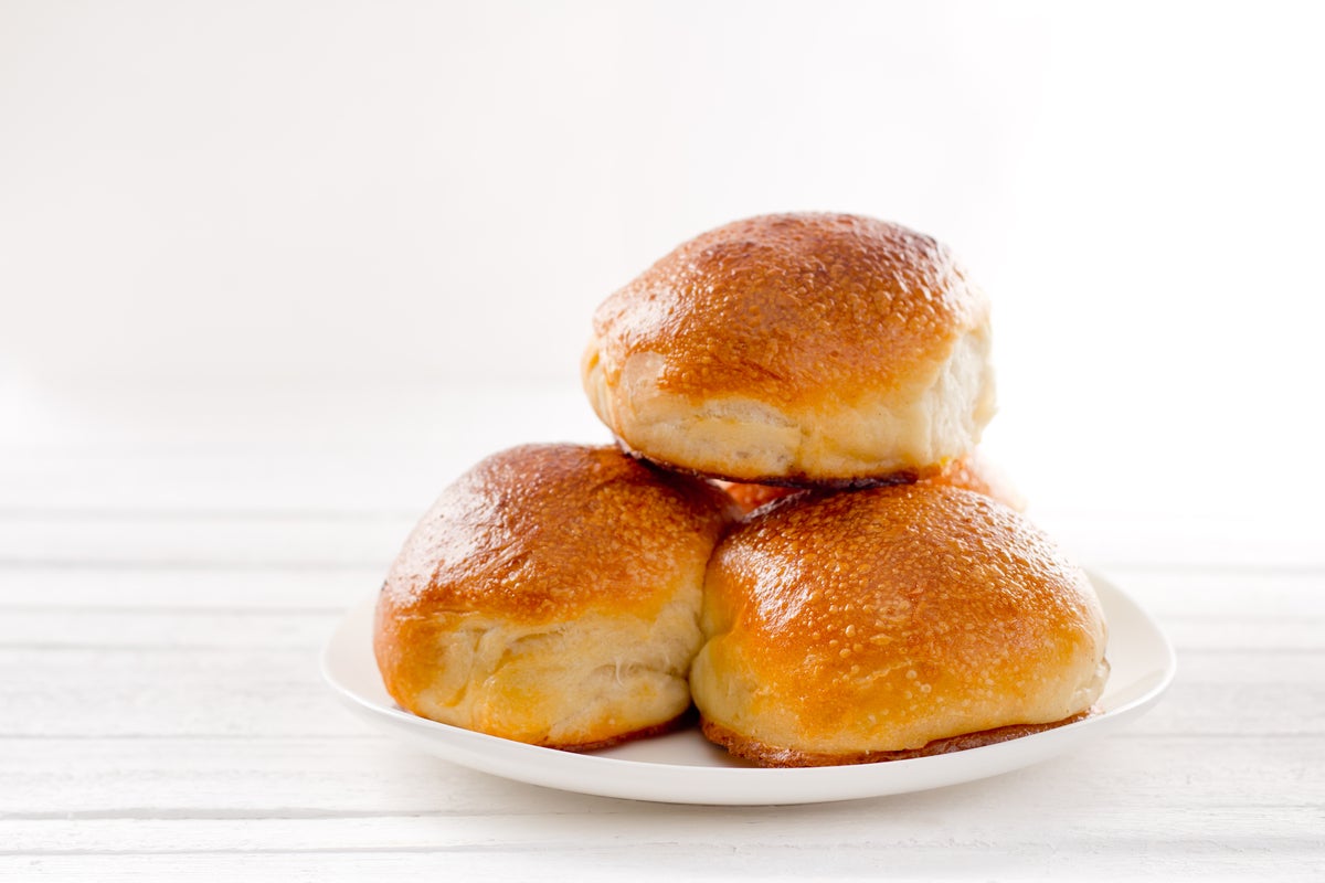 shutterstock 378840622 three rosy baked appetizing buns on a plate on a white background