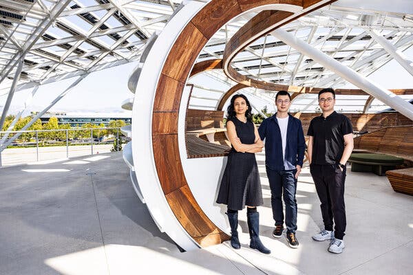 Anima Anandkumar, Yuke Zhu and Jim Fan in dark clothes in an airy setting, with wood and white spires.