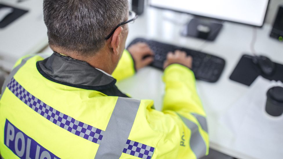 Police officer searching on computer