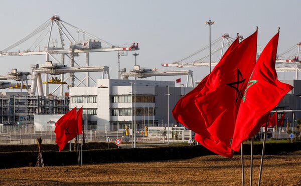 Moroccan flags flying near container cranes at the Tanger-Med port on the Strait of Gibraltar.