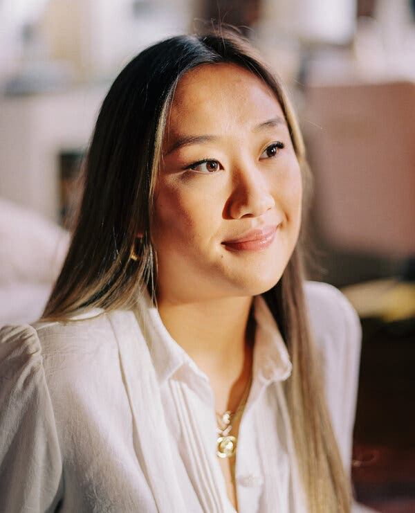 A portrait of Annie Wu Henry, who is wearing a white collared shirt and is looking off to the side as sun hits her face.