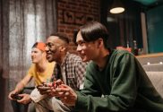 An image of three male gamers playing on a couch