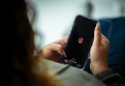 Woman looking at phone displaying Threads logo