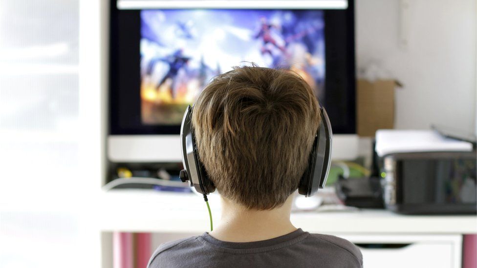 A boy playing a video game with headphones on