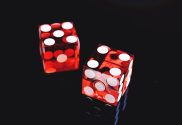 Red and white dice on a black backdrop